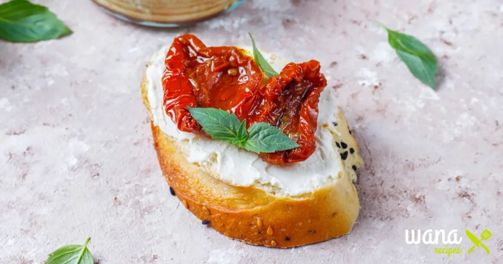  A vibrant red bowl of ajvar, a smoky red pepper and eggplant spread, garnished with parsley and served alongside fresh bread.