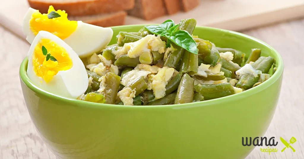 Edamame egg salad served in a white bowl with fresh herbs and sesame seeds.