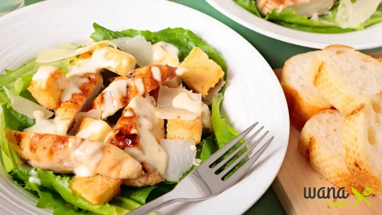 Buffalo chicken salad served in a bowl with fresh greens, cherry tomatoes, carrots, avocado slices, and creamy dressing