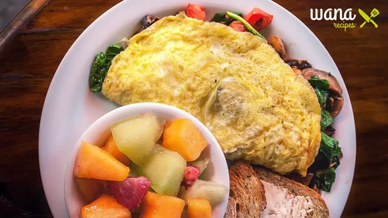 Delicious easy high protein breakfast with eggs, avocado toast, and fresh fruits on a wooden table.