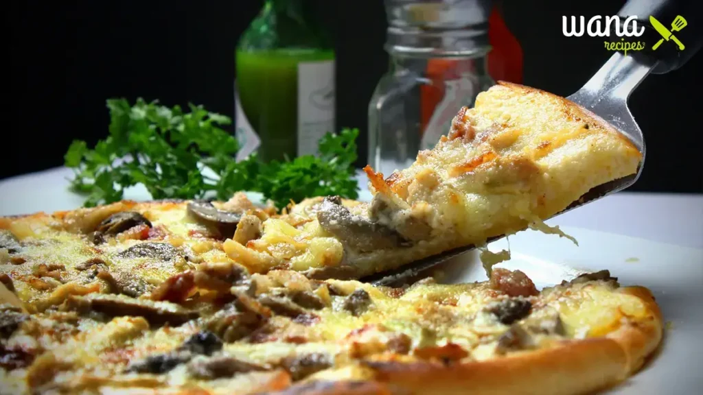 Freshly baked breakfast pizza with eggs, cheese, sausage, and vegetables served on a wooden board in a school cafeteria.