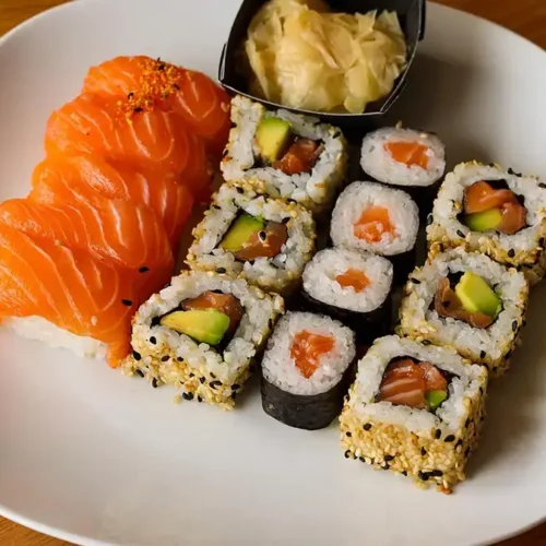 A plate of low-sodium sushi meal, featuring slices of salmon sashimi and sushi rolls with salmon, avocado, and sesame seeds.