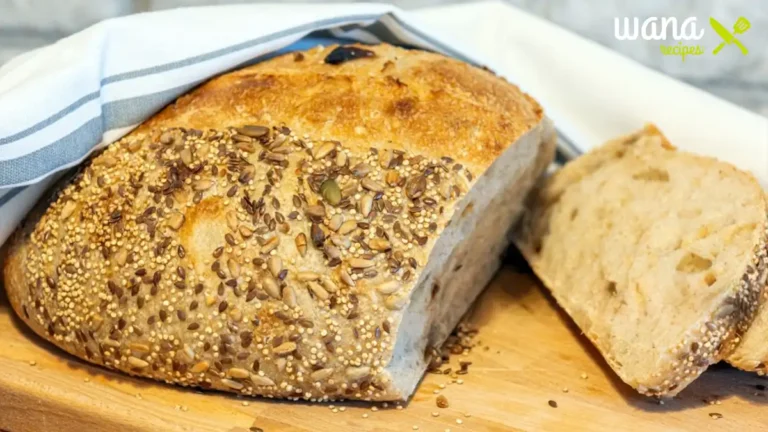 Freshly baked sunflower pumpkin seed bread with a golden crust, topped with crunchy sunflower and pumpkin seeds, placed on a wooden cutting board